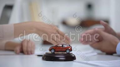 <strong>桌</strong>上的汽车玩具，妇女在<strong>背景</strong>下<strong>签</strong>署车辆购买或保险